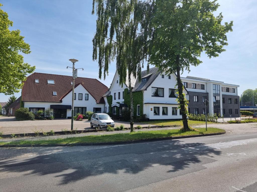 uma rua com casas e um carro na estrada em Hotel Rademacher em Wittmund