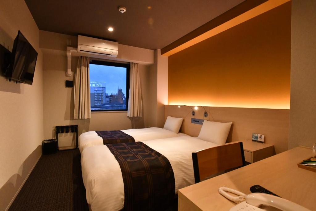 a hotel room with two beds and a sink at FL Hotel Dotonbori in Osaka
