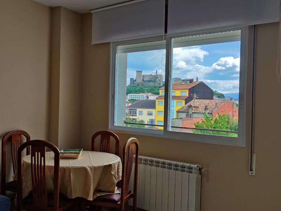 stół i krzesła w pokoju z oknem w obiekcie Noly Apartamento w mieście Monforte de Lemos