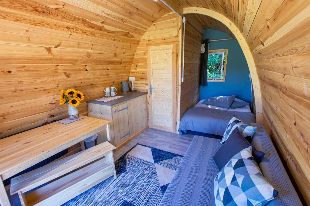 a log cabin bedroom with a bed and a desk at The Woolpack Glamping in Maidstone