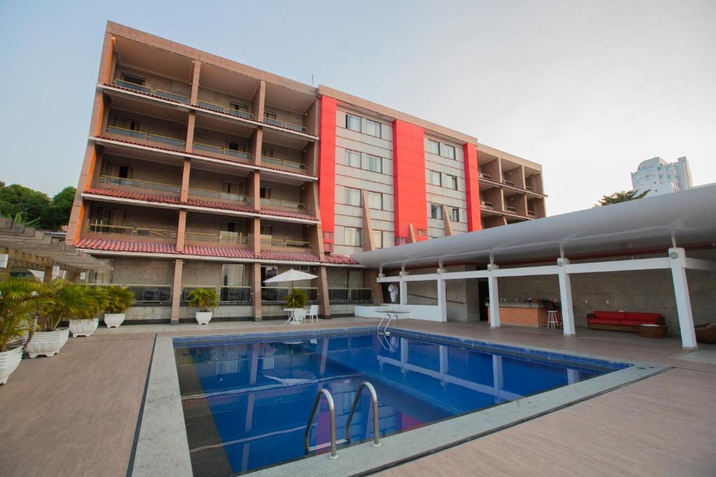 ein Hotel mit einem Schwimmbad vor einem Gebäude in der Unterkunft Da Vinci Hotel & Conventions - by Easy Hotéis in Manaus