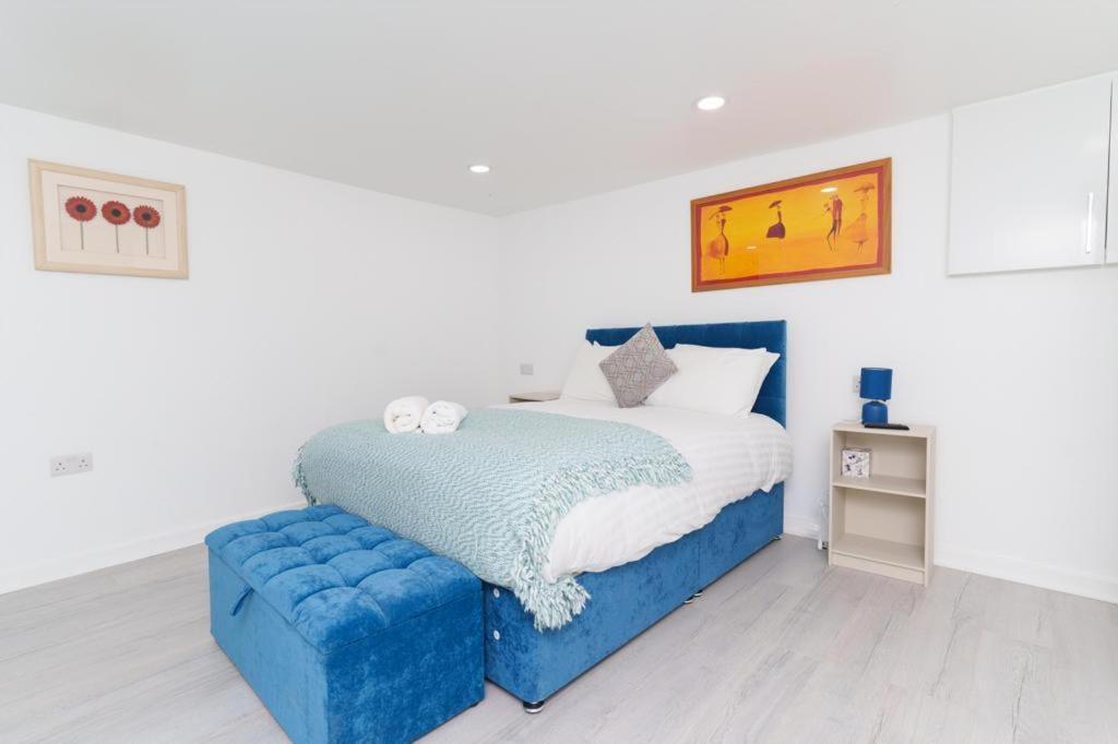 um quarto com uma cama azul e um repousa-pés azul em Monroe House Leeds em Leeds