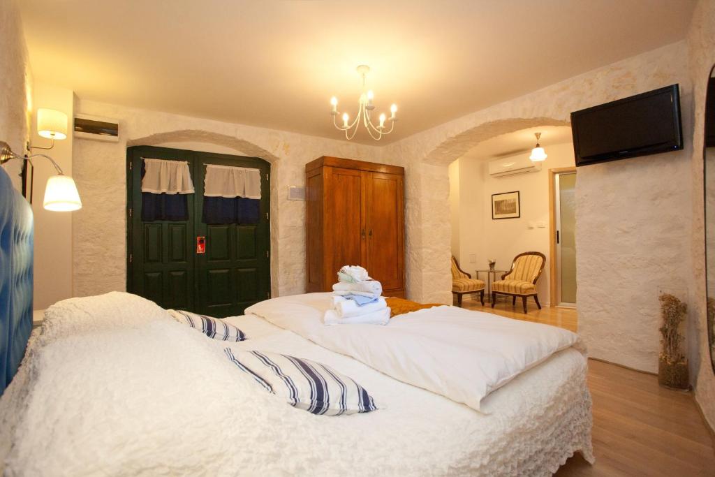 a bedroom with two beds and a tv on the wall at Bed & Breakfast Vila Baguc in Split