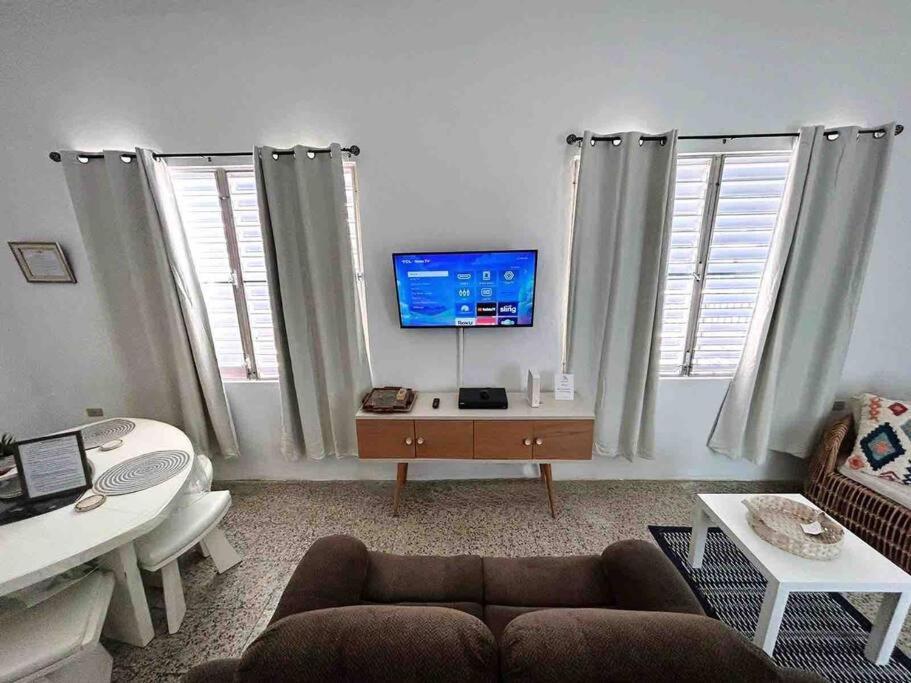 a living room with a couch and a flat screen tv at House Salinas - The best part of your getaway in Salinas