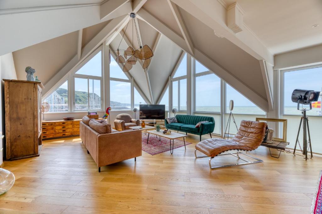 uma sala de estar no sótão com muitas janelas em Le poséidon, gîte EXCEPTIONNEL face à la mer avec spa, terrasse, 4 chambres UN VRAI COUP DE COEUR em Fécamp