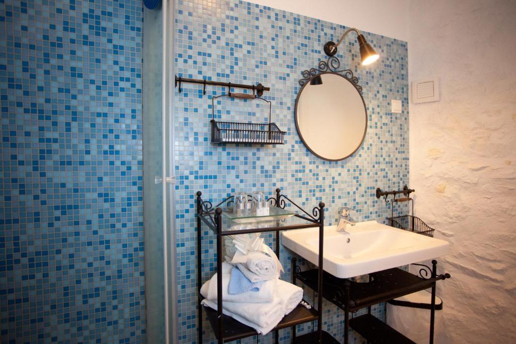 a blue tiled bathroom with a sink and a mirror at Bed & Breakfast Vila Baguc in Split