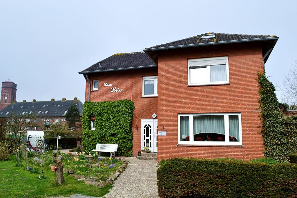 una casa de ladrillo rojo con puerta blanca en Haus Ohio Garni, en Borkum