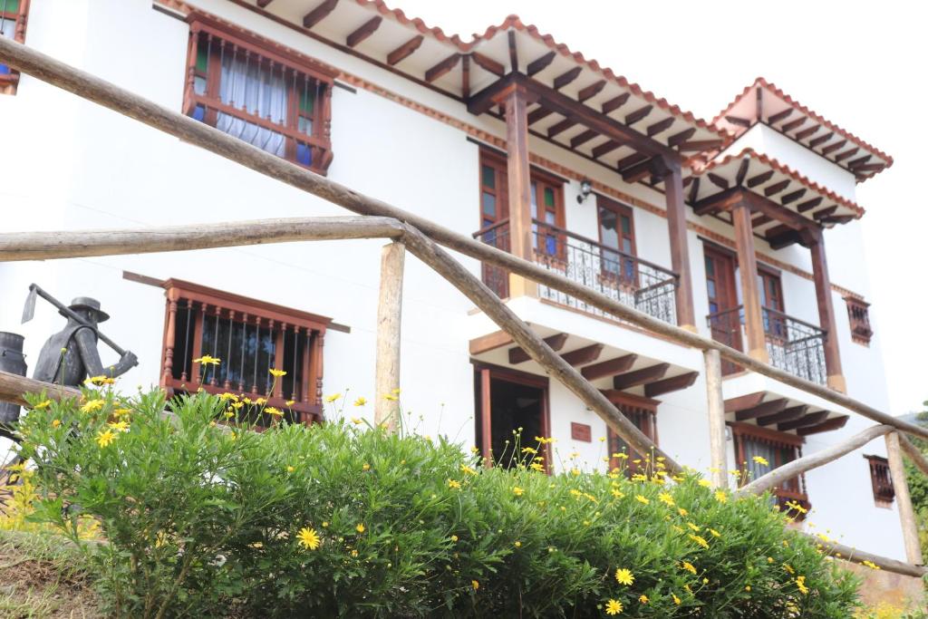 un edificio con ventanas y flores delante de él en Casa El Retiro - Villa de Leyva, en Villa de Leyva