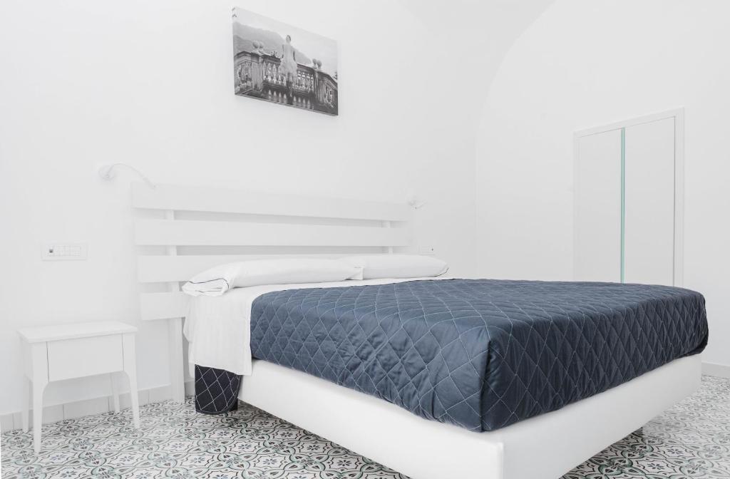 Dormitorio blanco con cama blanca y negra en Na Stanza in centro en Ravello