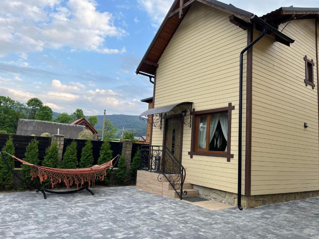 a house with a hammock next to a fence at Arkan in Mykulychyn