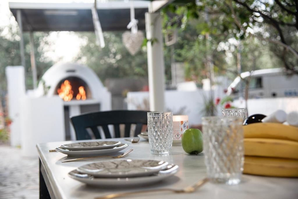 a table with plates and glasses and a fireplace at Kos Gaia Garden House 