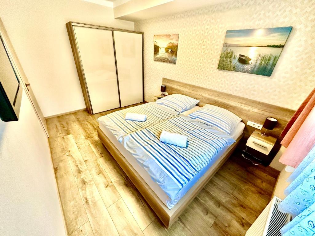 1 dormitorio con 1 cama con 2 toallas en Unio Vendégház 3, en Siófok