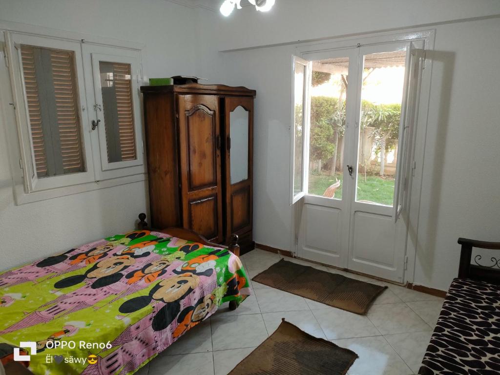 a bedroom with a bed and a dresser and a window at الساحل الشمالي in El Alamein