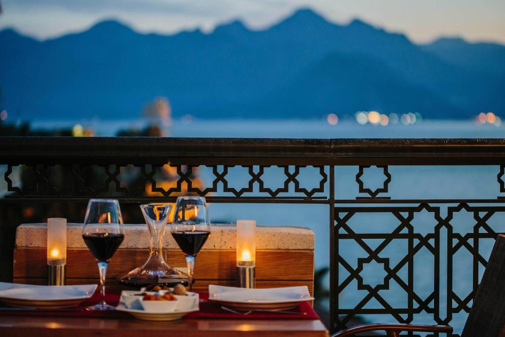 a table with glasses of wine on a balcony at Antalya Inn Hotel in Antalya