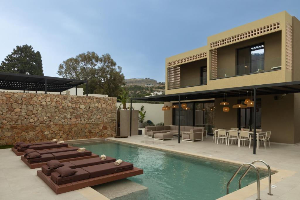 una casa con piscina frente a una casa en STALèA Luxury Villa en Pefki Rhodes