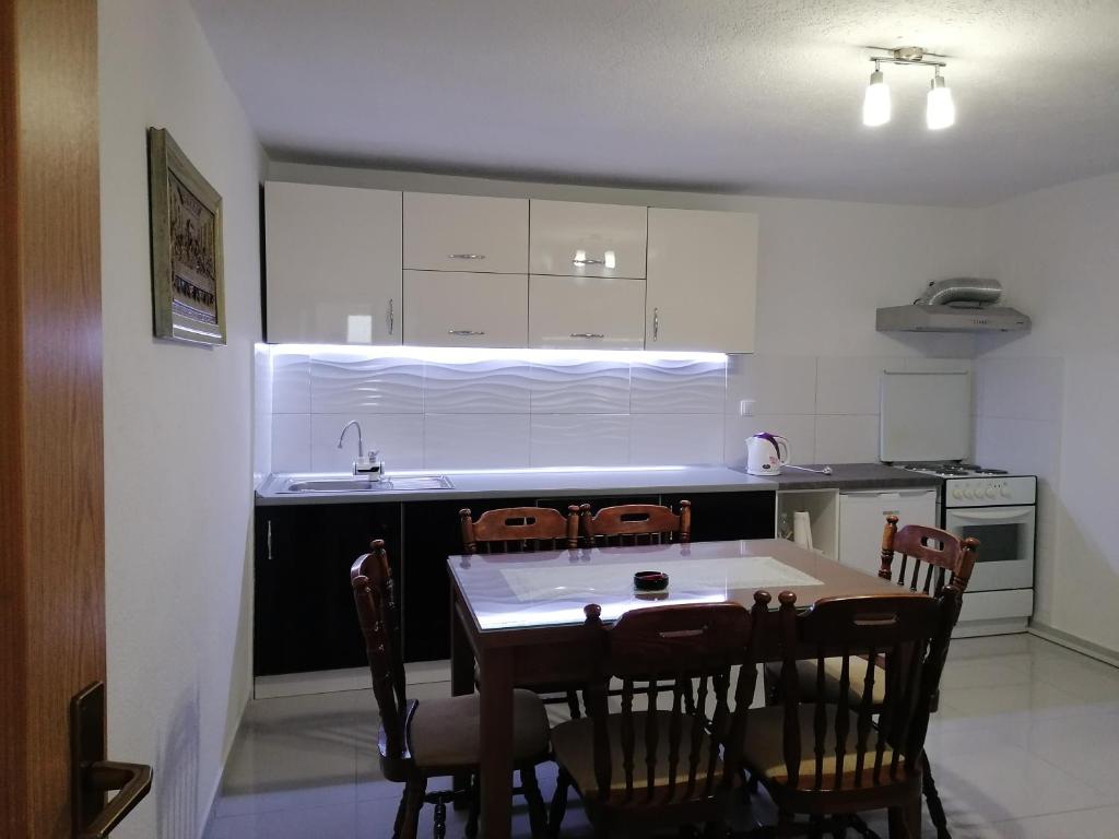 een keuken met een tafel en stoelen in een kamer bij Bevanda in Široki Brijeg