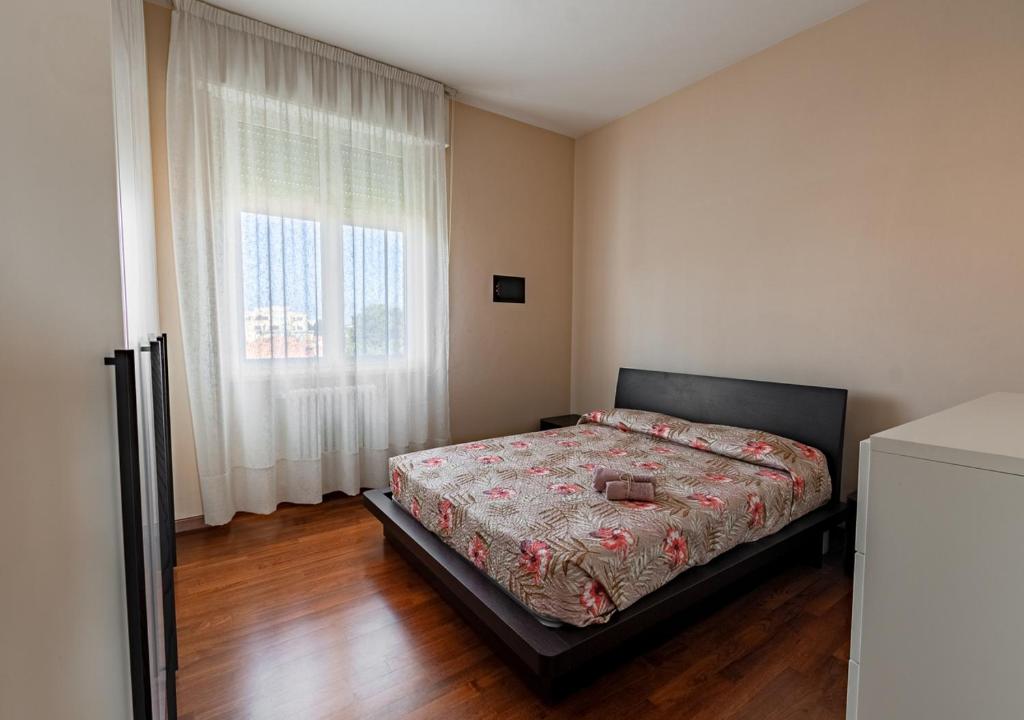 a bedroom with a bed and a large window at Luxury House near train station in Livorno
