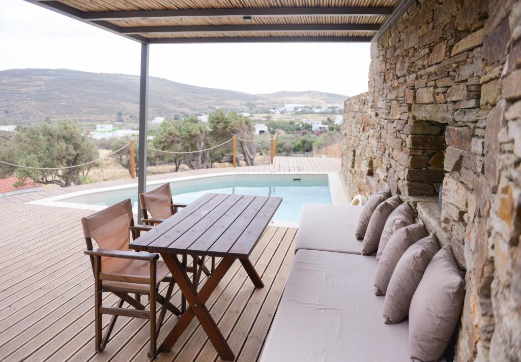 une terrasse avec une table, des chaises et une piscine dans l'établissement Villa Prasini, à Agios Sostis