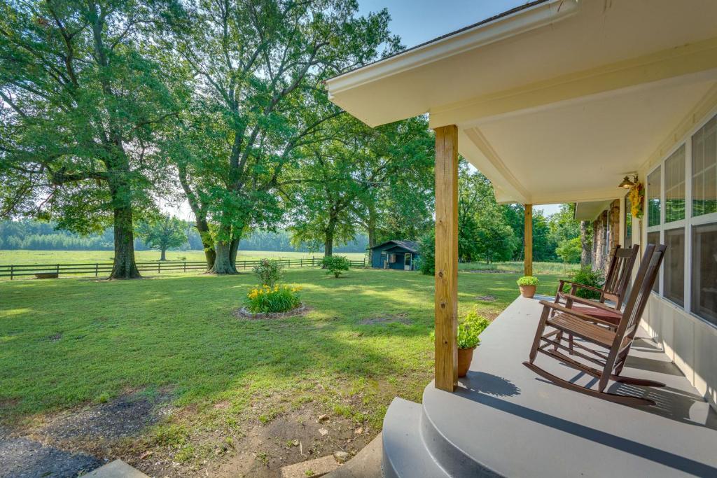 eine Veranda eines Hauses mit einer Bank und einem Hof in der Unterkunft Delaware Vacation Rental Walk to Lake Dardanelle! 