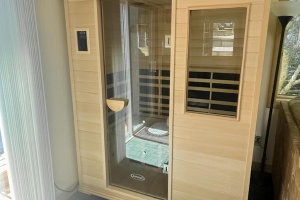 a shower with a glass door in a room at Beachcombers Hideaway in Florence