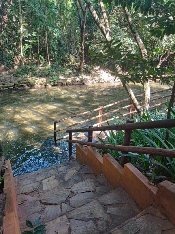 een houten hek naast een rivier met een brug bij Apart Flat Aguas da Serra in Rio Quente