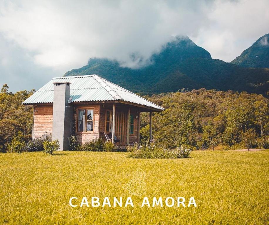 a small house in a field in front of a mountain at Vilaggio Bengazi in Treviso