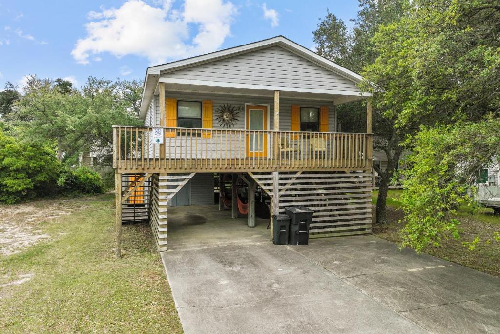a house with a large deck on top of it at Sunny Daze KDH by Village Reality in Kill Devil Hills