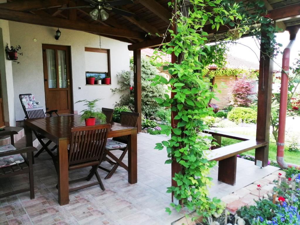 a patio with a wooden table and a green plant at SAGA in Osijek