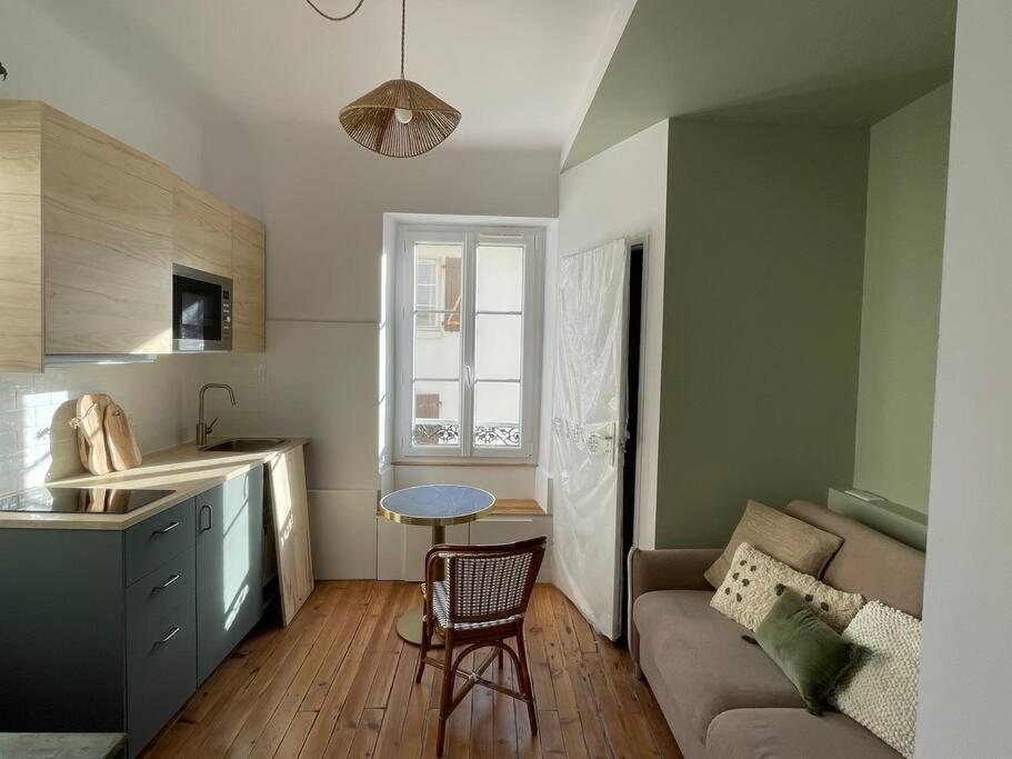 een keuken en een woonkamer met een bank en een tafel bij Studio Biarritz 2 min Halles, 3 min plages, plein centre. in Biarritz