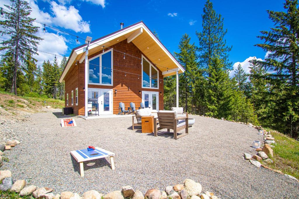 una cabaña de madera con una mesa de picnic y un banco en Little Tooth Retreat, en Sandpoint