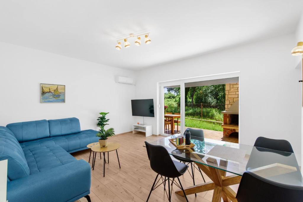 a living room with a blue couch and a table at Apartments Villa Verde in Novigrad Istria