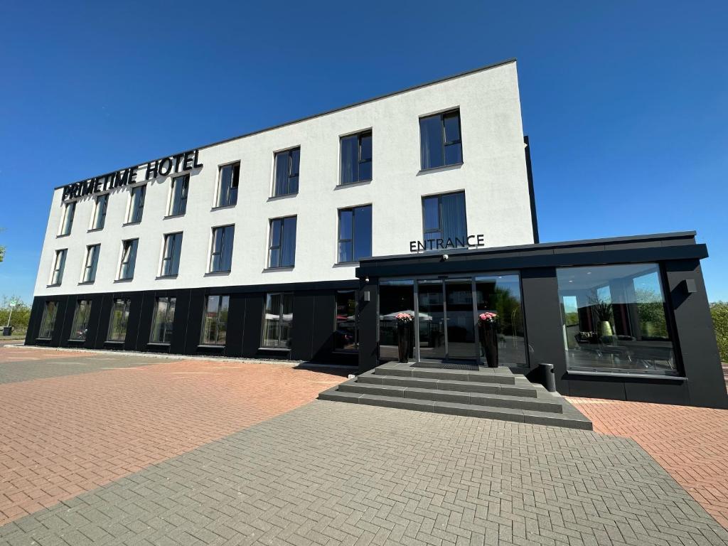 a white building with a sign on the front of it at Primetime Hotel in Gießen