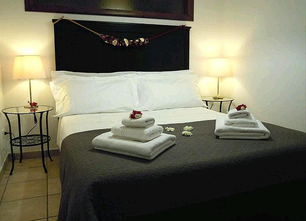 a bedroom with towels on a bed with two lamps at Sicula Solemare in Ispica