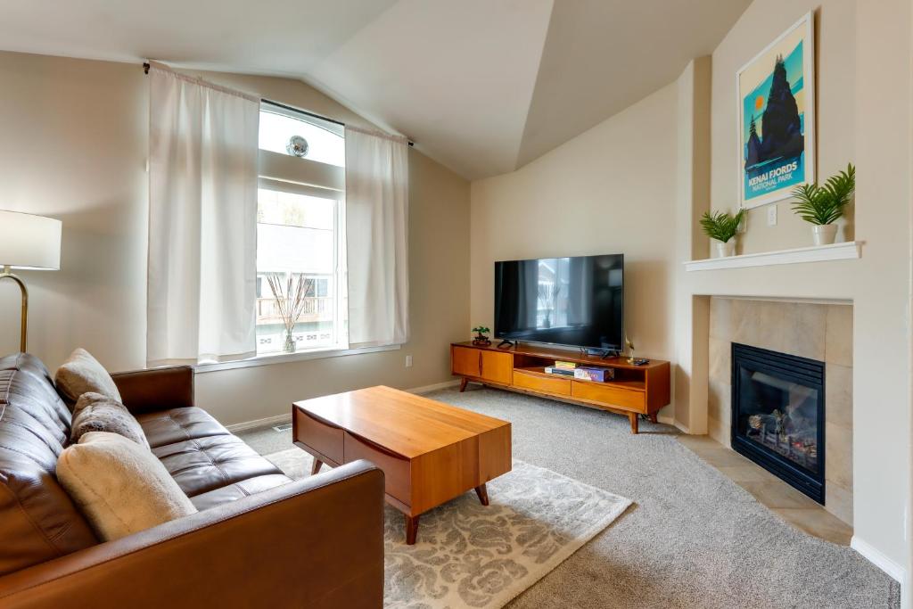 un soggiorno con un divano e una TV di Alaska Retreat with Balcony, Near Earthquake Park! ad Anchorage