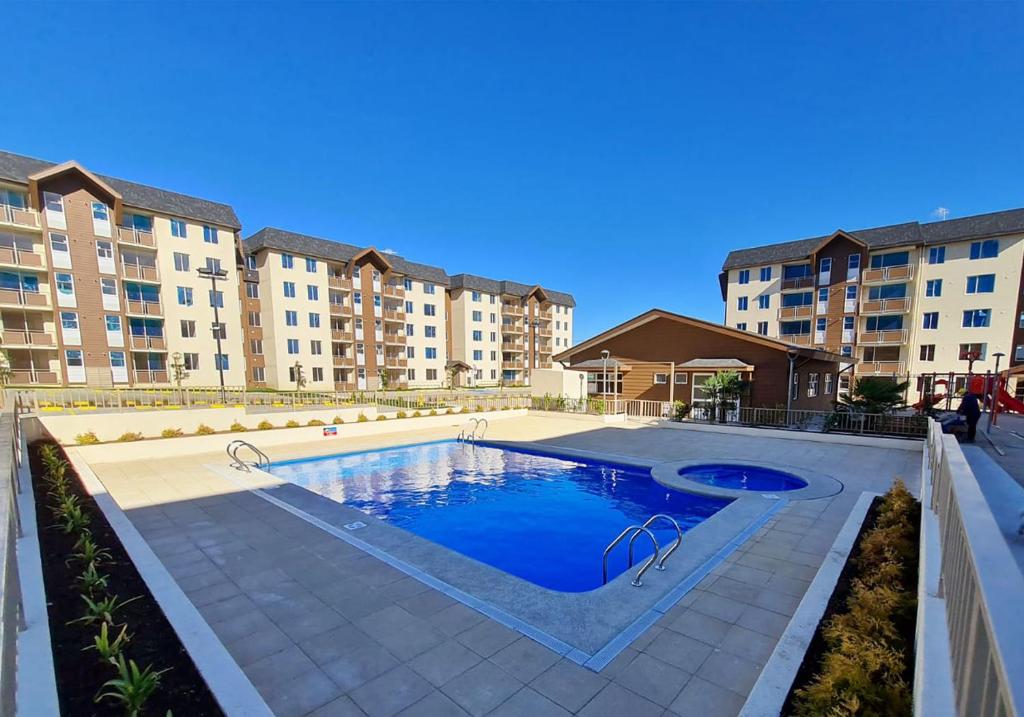una piscina frente a algunos edificios de apartamentos en Apartamento Villarrica, en Villarrica