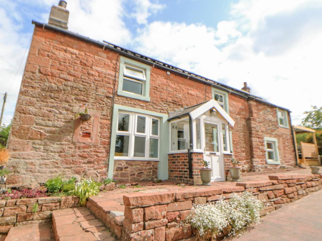 a brick house with a brick wall at Rock Cottage in Penrith