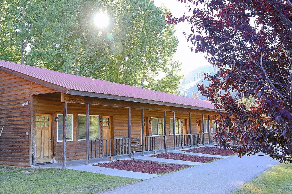 a wooden cabin with a walkway in front of it at Southfork Lodge - Riverside Inn in Lowman