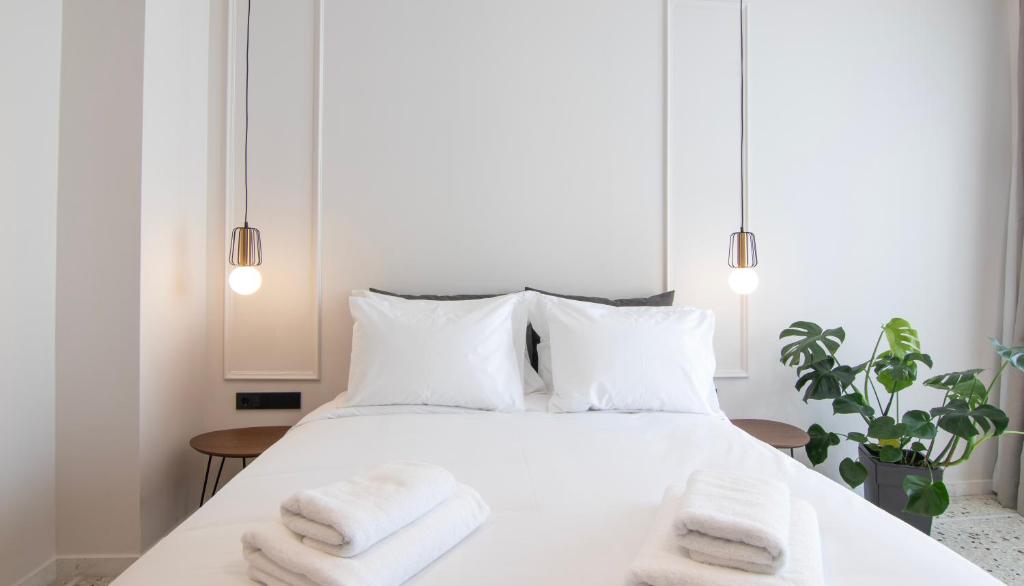 Ένα ή περισσότερα κρεβάτια σε δωμάτιο στο Mythodea Athens Suites