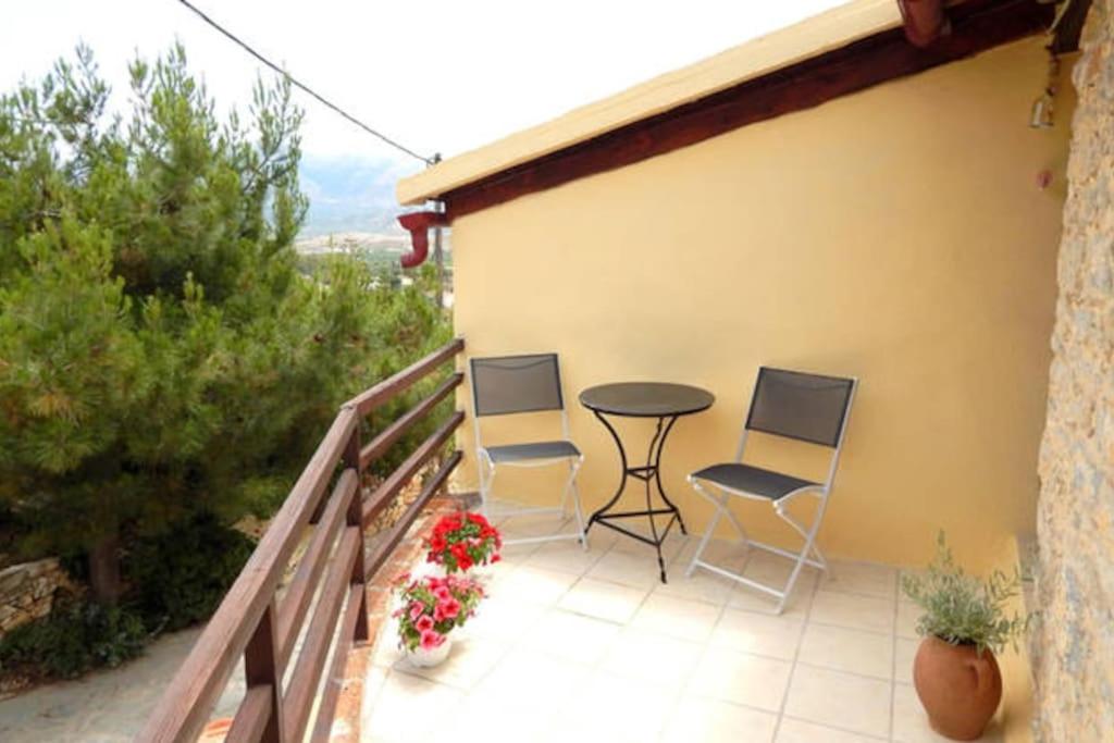 a patio with chairs and a table on a balcony at Traditional stone house camari in Apóstoloi