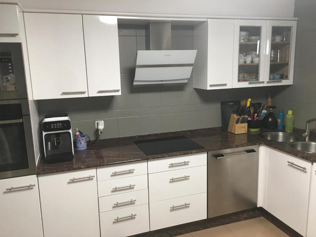 a kitchen with white cabinets and a counter top at Sweet Home in Moaña