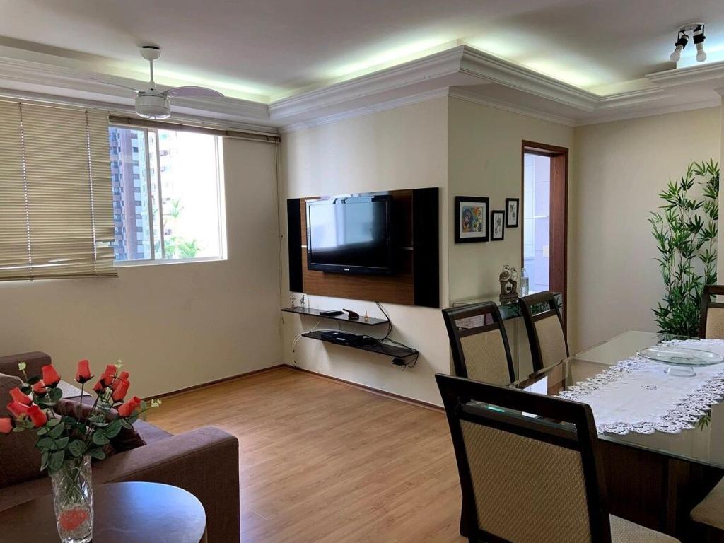 uma sala de estar com uma mesa de jantar e uma televisão em Apto 2 quartos, centro, garagem, ar condicionado em Londrina