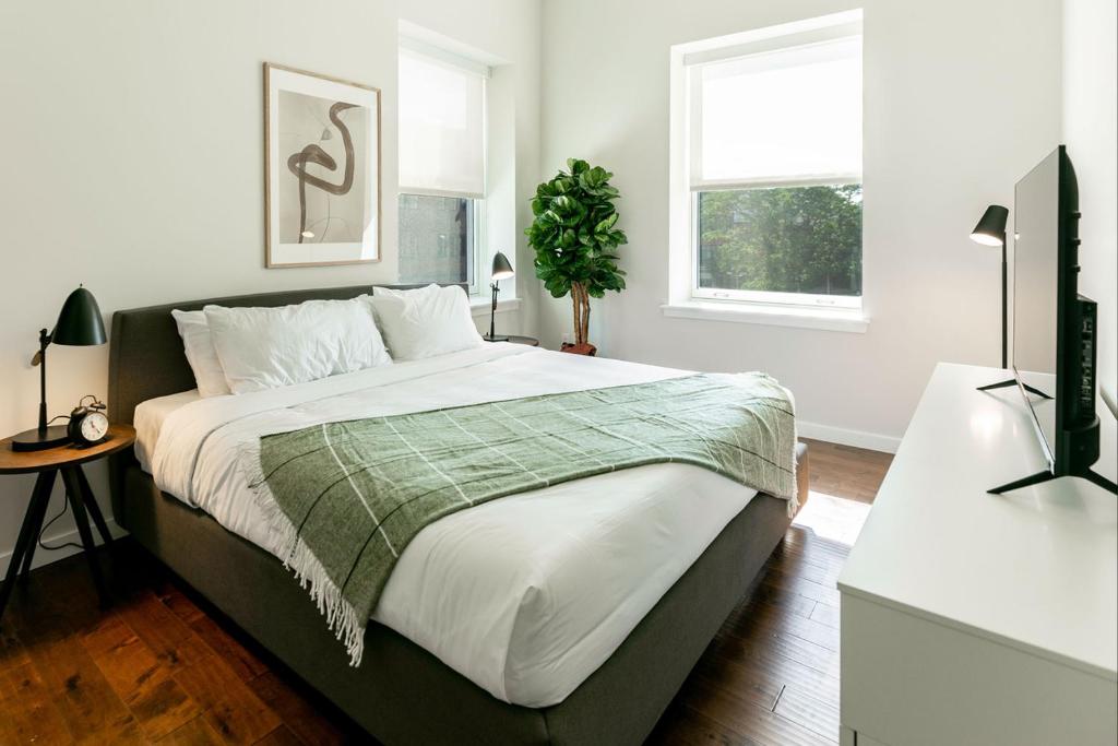 une chambre avec un grand lit et une fenêtre dans l'établissement Kislak 503 Luxurious 2BR Retreat Above the City, à Newark