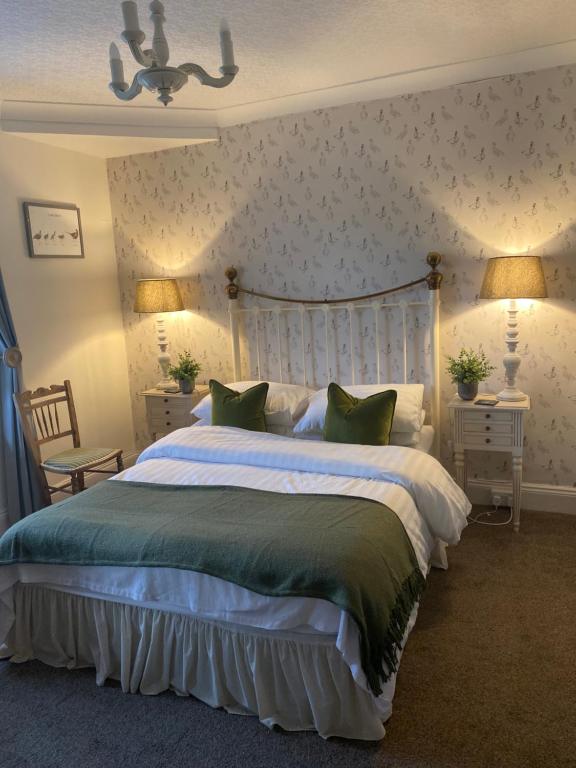 um quarto com uma cama grande e almofadas verdes em Bewerley Hall farm em Harrogate