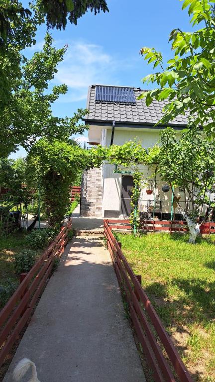 a walkway leading to a house with a red fence at Casa Gabi in Corbu