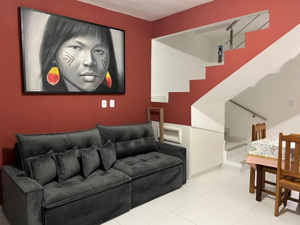 een woonkamer met een bank en een schilderij aan de muur bij Lindo Apê em Coroa Vermelha BA in Santa Cruz Cabrália