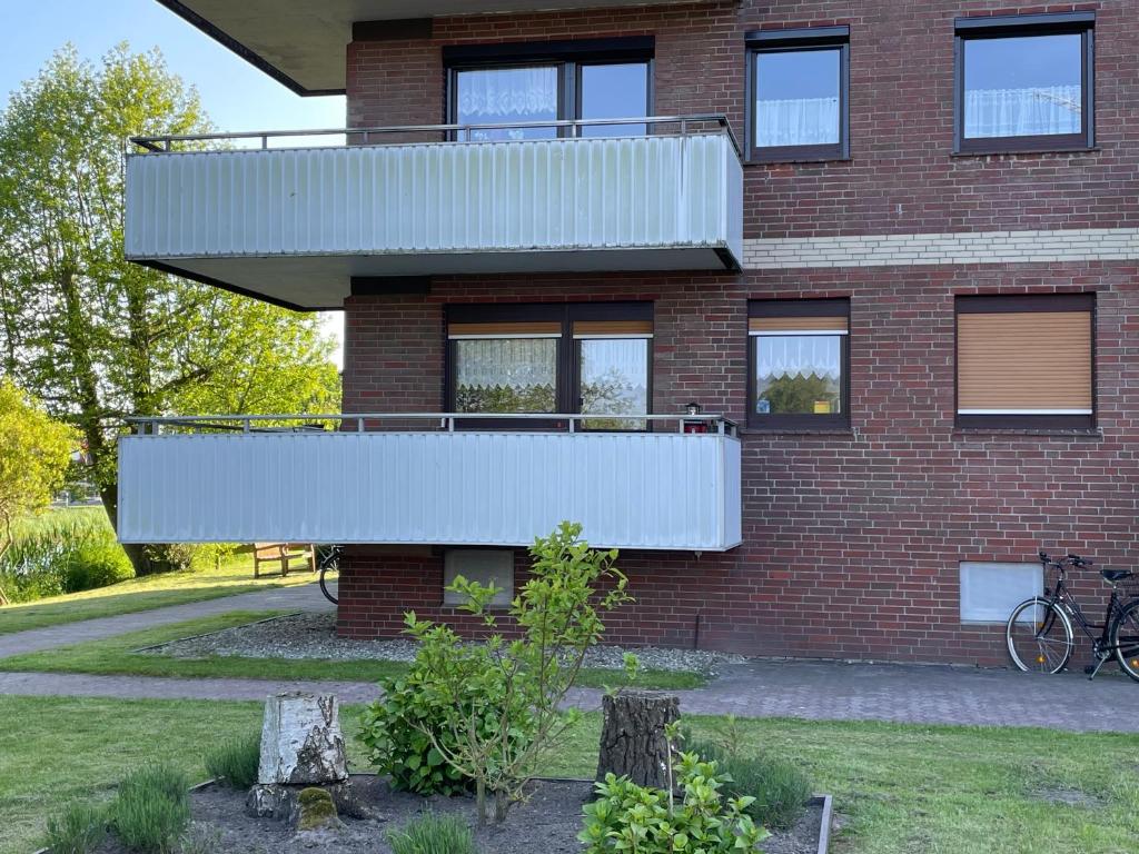 een gebouw met een balkon aan de zijkant bij Ferienwohnung Dornumersiel Nordseeglück am Siel 2024 renoviert in Dornum