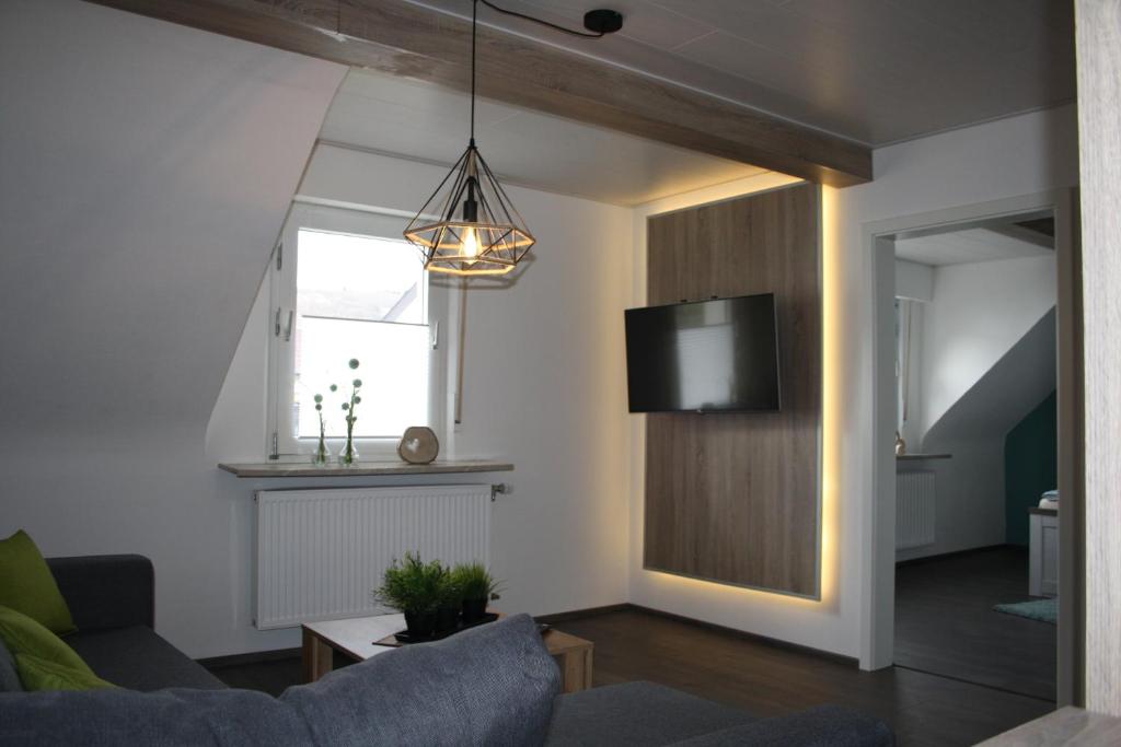 een woonkamer met een bank en een tv bij Ferienwohnung zur Trübenbach in Kirn