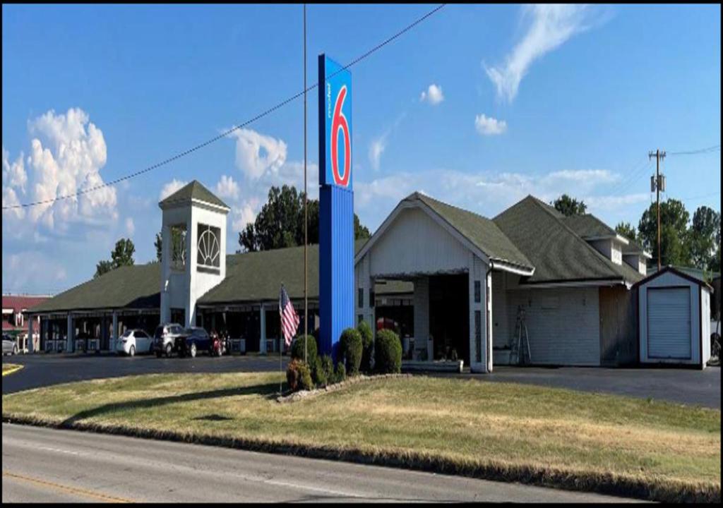 a blue pole with a sign in front of a building at Motel 6-Sallisaw, OK in Sallisaw