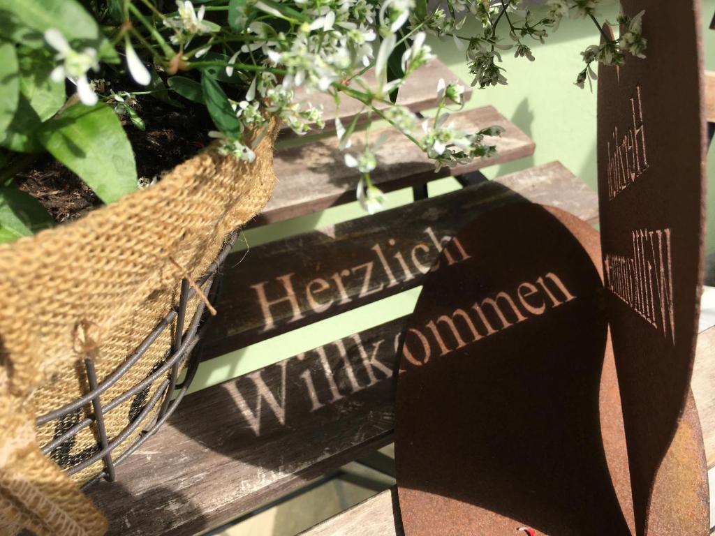 een bord op een bank met planten erop bij Ferienwohnung Sabine Jacoby in Winningen