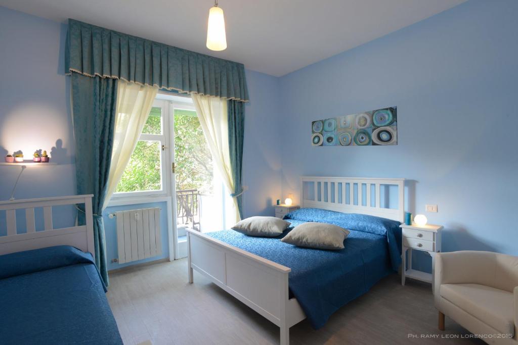 a blue bedroom with a bed and a window at Magna Cura in Rome